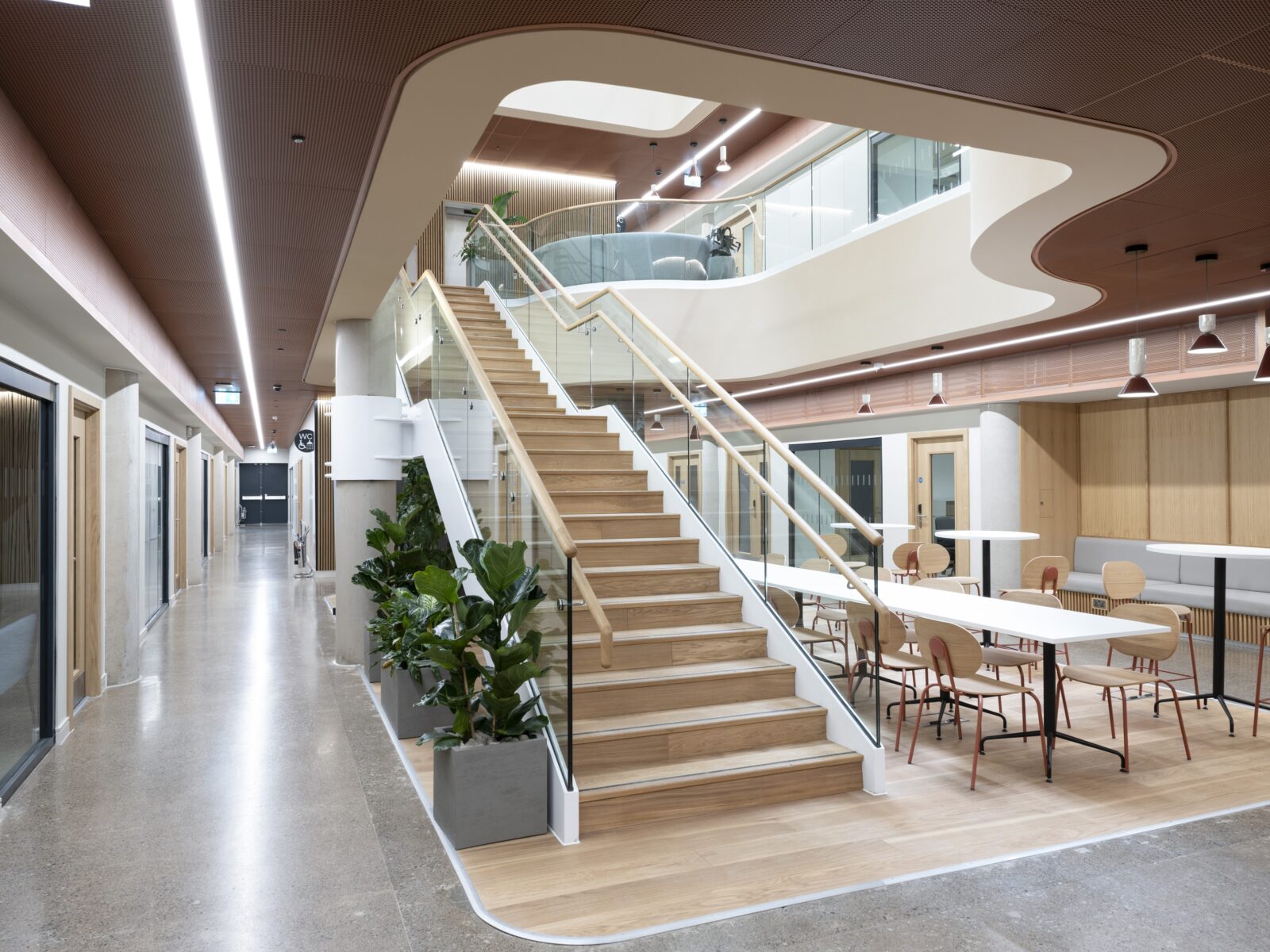Glasgow health innovation Interior view of the Health Innovation Hub atrium featuring an open staircase, collaborative seating area and biophilic design