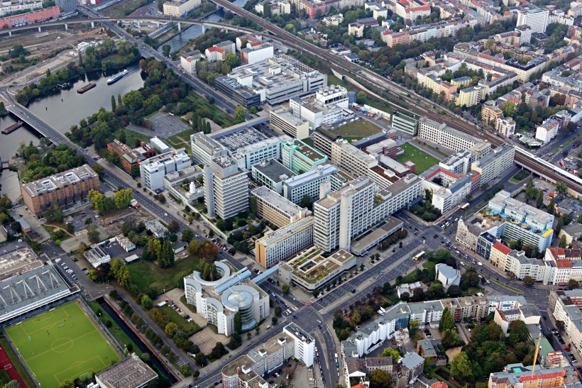 Aerial view of an urban research campus with large buildings, roads and surrounding cityscape