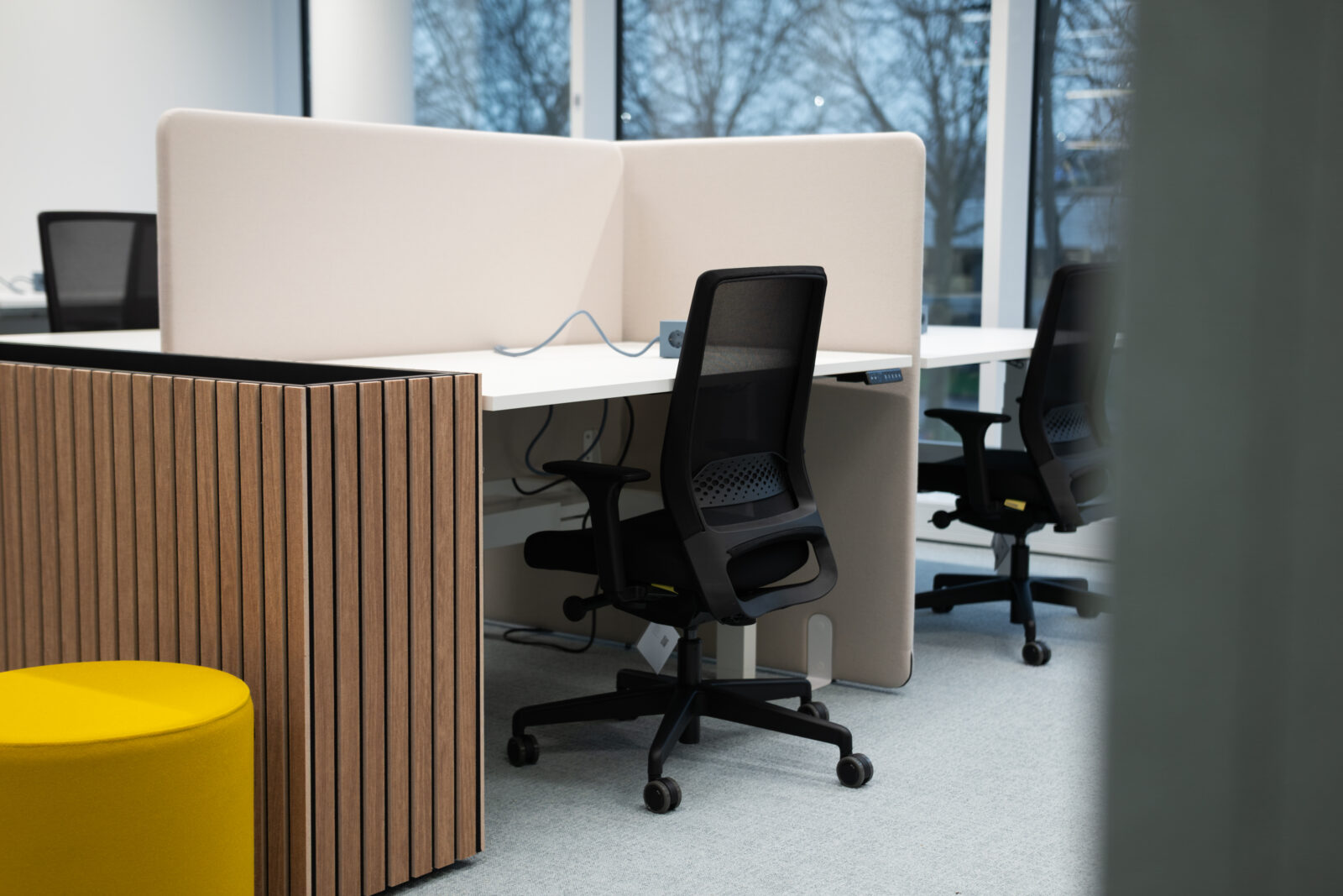 Empty desk with chair, planter and yellow pouf in a modern interior