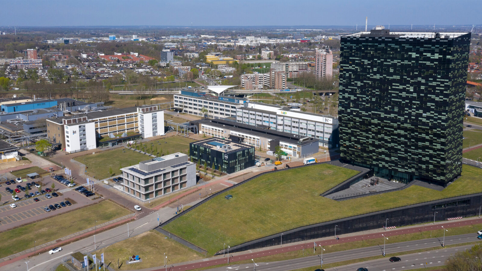 Aerial view of the Kadans Science Partner campus in Nijmegen with the iconic black tower and surrounding science cluster buildings.