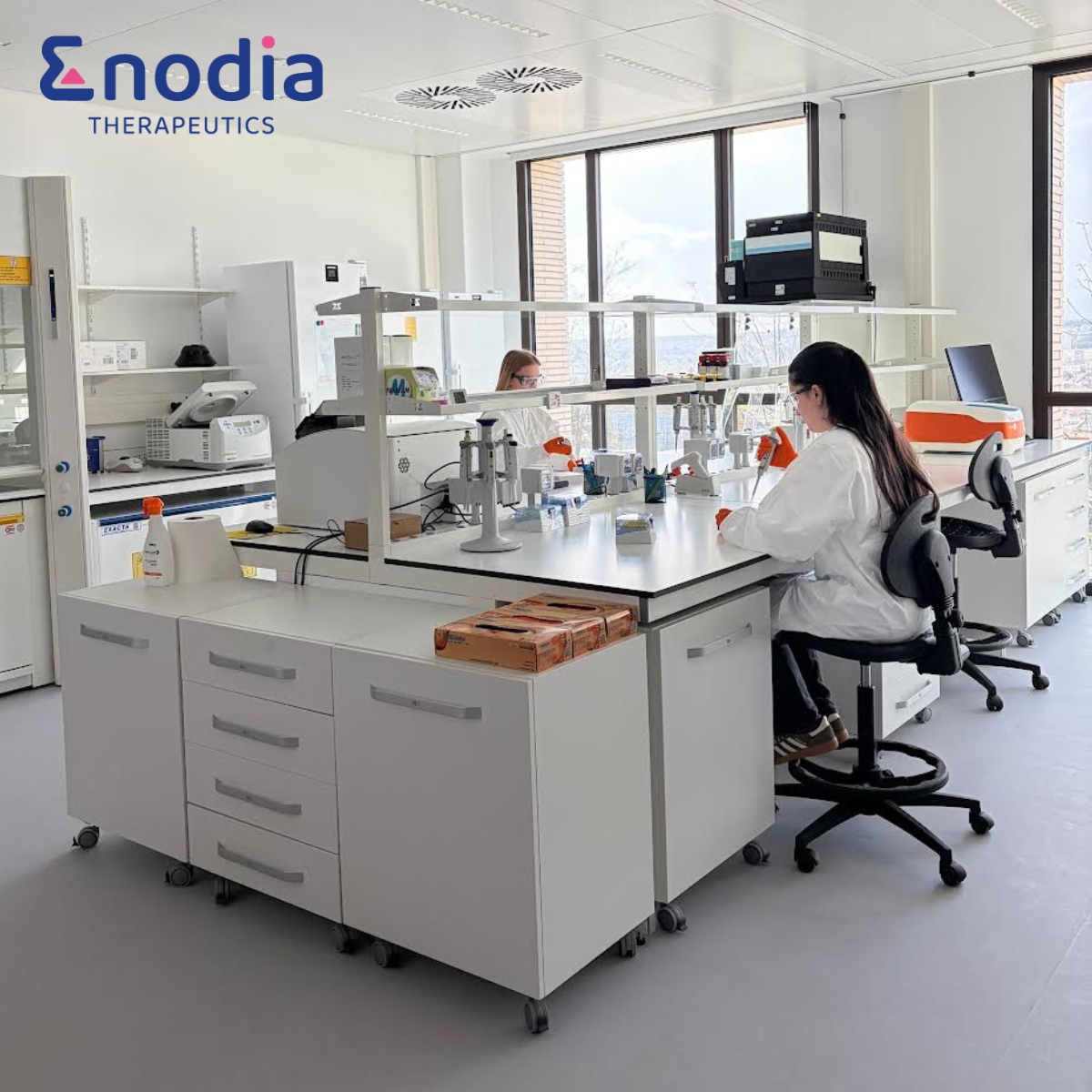 Laboratory workspace with scientific equipment and Enodia logo